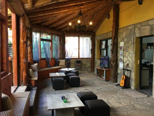 圣卡洛斯-德巴里洛切Italia Inn Hostel的带沙发和桌子的客厅以及吉他