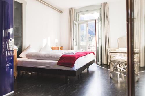 贝尔金贝尔京科尔豪斯酒店的一间卧室配有一张床铺,床上铺有红色毯子