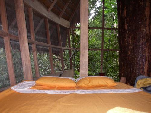 莱蒂西亚塔尼博查山林小屋的树屋的一张床位,配有两个枕头