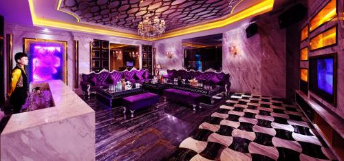 广州克莱顿酒店（近琶洲展馆）的站在一个配有紫色桌椅的房间的人