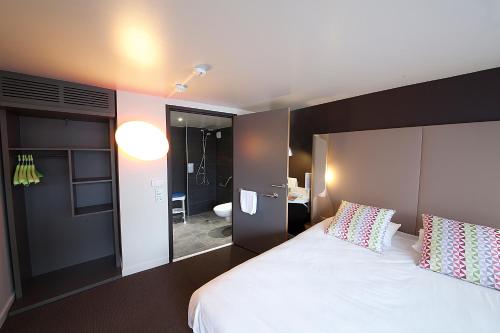奥比埃钟楼克雷蒙费兰德奥比耶尔酒店的卧室配有一张白色大床和镜子