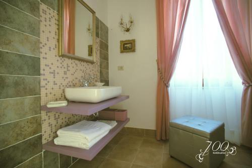 阿斯科利皮切诺Luxury B&B '700的一间带水槽和镜子的浴室以及窗户。