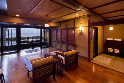 东伊豆町包穗日式旅馆的客厅配有家具,享有海景