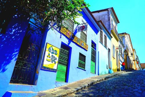 萨尔瓦多Hostel Galeria 13的鹅卵石街道上的一座蓝色和白色的建筑