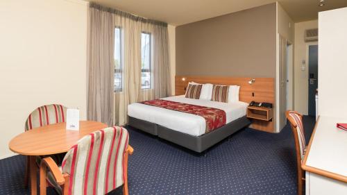 奥克兰奥克兰机场中心酒店的酒店客房配有一张床铺和一张桌子。