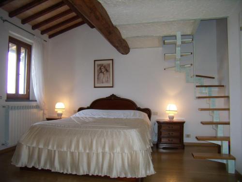 蒙泰斯佩尔托利B&B Il Poggetto的一间卧室设有一张床和一个螺旋楼梯