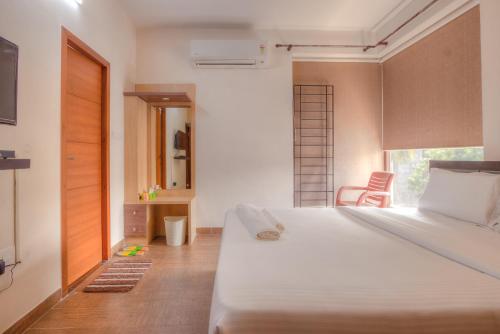钦奈Kolam Serviced Apartments - Adyar.的卧室设有一张白色大床和一扇窗户。