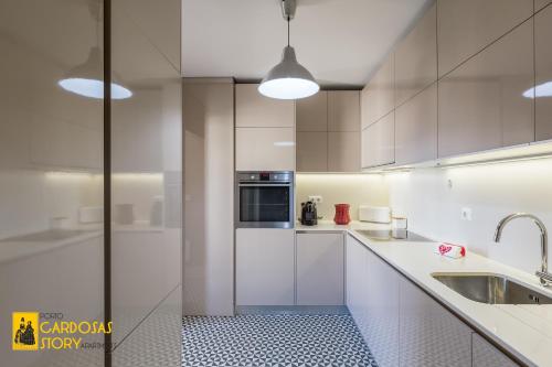 波尔图Cardosas Story Apartments by Porto City Hosts的白色的厨房配有水槽和微波炉
