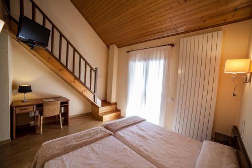 拉加玛艾佩德拉阿维特酒店的一间带大床和楼梯的卧室