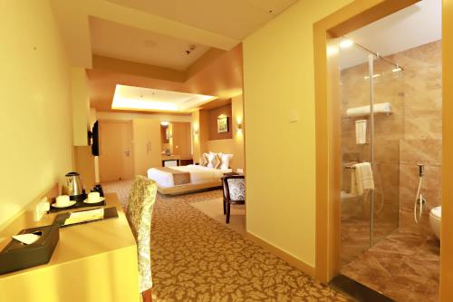 巴特那帕特里普特拉大陆酒店的酒店客房设有带一张床和淋浴的浴室