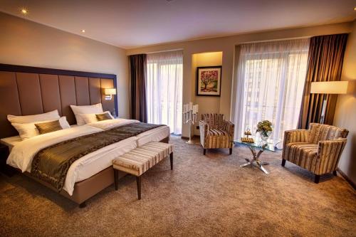 杜塞尔多夫法伍儿酒店的一间卧室配有一张大床和两把椅子