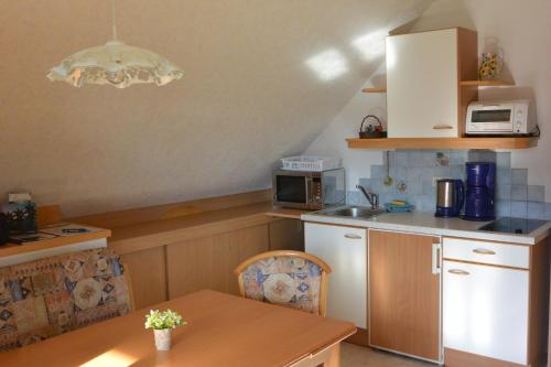 陶普利茨Ferienwohnung Pöreiterhof的一间带桌子和微波炉的小厨房
