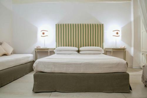 加利波利Domus Dejana的一间卧室设有两张床和两张带台灯的桌子。
