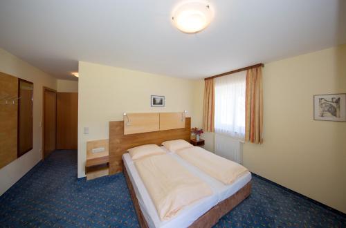 UntermühlGasthof - Landhotel Ernst的一间卧室设有一张大床和一个窗户。
