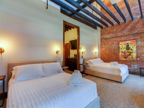 帕迪尤卡The 1857的一间卧室设有两张床和砖墙