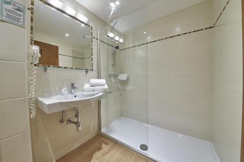 萨尔巴赫阿尔本利克酒店的带淋浴、盥洗盆和浴缸的浴室