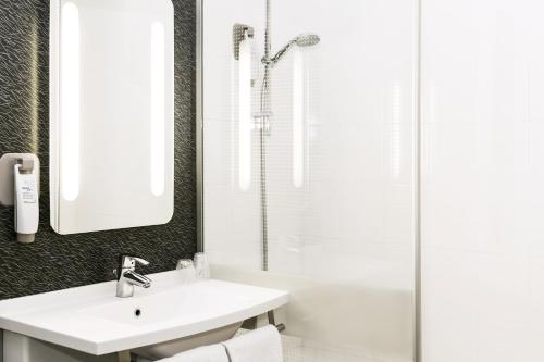 索西姆米卢斯拿破仑法兰西岛大区宜必思酒店的白色的浴室设有水槽和淋浴。