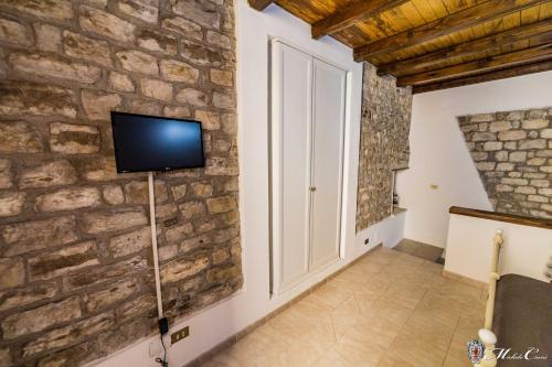 斯波莱托Appartamento di Lucrezia的客厅设有石墙和电视。