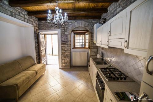 斯波莱托Appartamento di Lucrezia的一间厨房,内设白色橱柜和沙发