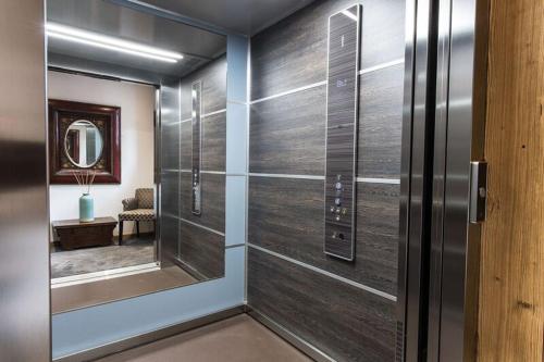 梅杰夫Le Chalet Blanc的走廊上设有滑动玻璃门和镜子