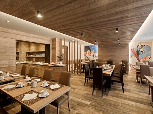 摩德纳迪-坎皮格里奥Hotel Garni Arnica ***S的餐厅铺有木地板,配有桌椅