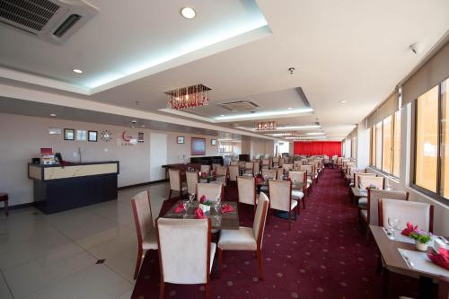 哥打京那巴鲁加耶中心酒店的一间带桌椅的用餐室和一间酒吧