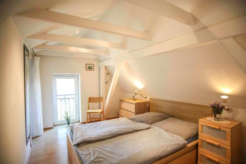 圣彼得奥尔丁Ferienwohnung Wieben的一间卧室配有一张床、一张书桌和一个窗户。