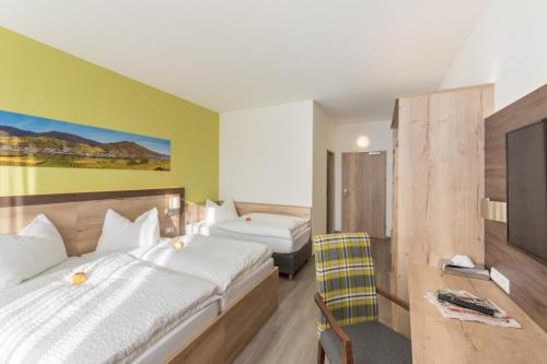 LoosdorfSleepin Premium Motel Loosdorf的酒店客房,配有两张床和椅子