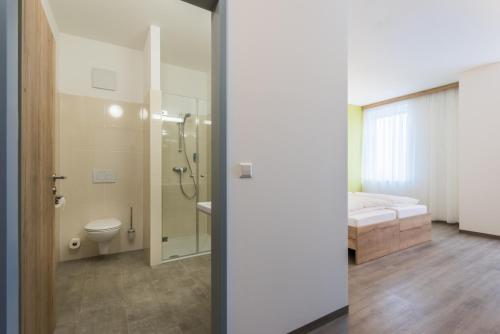 LoosdorfSleepin Premium Motel Loosdorf的带淋浴和卫生间的浴室以及1张床。