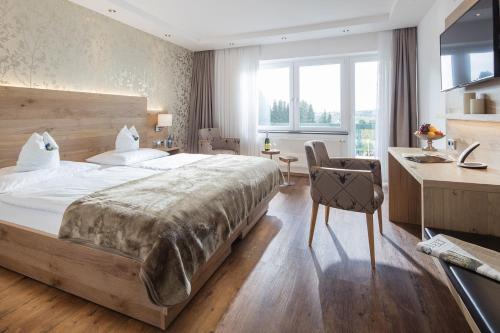 宁布雷希特德里奇维勒霍夫酒店的一间大卧室,配有一张大床和一张书桌