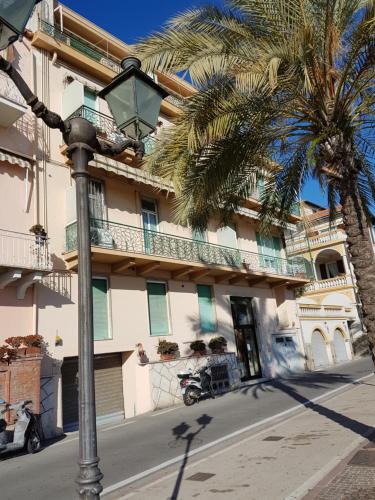 圣雷莫Appartamento Trento Trieste的棕榈树建筑前的街道灯