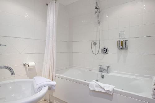 利奇菲尔德大教堂宾馆的白色的浴室设有浴缸和水槽。