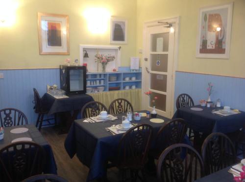 大雅茅斯克里斯伍德贵宾酒店的一间配备有蓝色桌椅和电视的用餐室