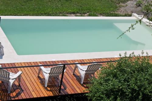 维拉卡洛斯帕兹卡瓦尼亚斯派提提山林小屋的一个带椅子的甲板和一个游泳池