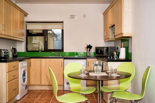 朗福德Cathedral View Apartments的厨房配有绿色椅子和桌子
