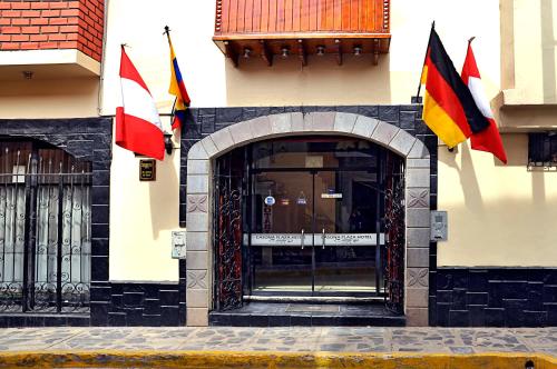 普诺Casona Plaza Hotel Centro的门前有旗帜的建筑物