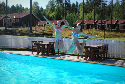 雷克桑德莫斯克根酒店的穿泳衣的两名女孩跳入游泳池