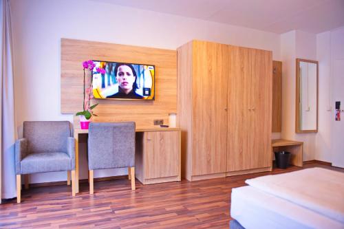 柏林柏林市酒店的客房设有书桌和墙上的电视