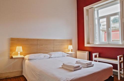 波尔图波尔图斯巴特旅馆的一间卧室设有一张红色墙壁和窗户的床