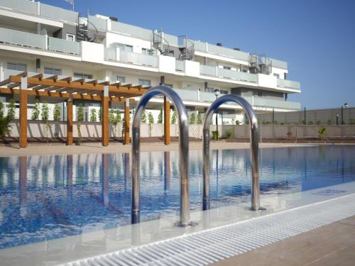 厄尔梅达诺Luxury Apartment Las Terrazas的大楼前的游泳池