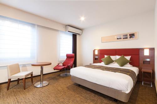 东京MYSTAYS 羽田酒店的酒店客房带一张床、一张桌子和椅子