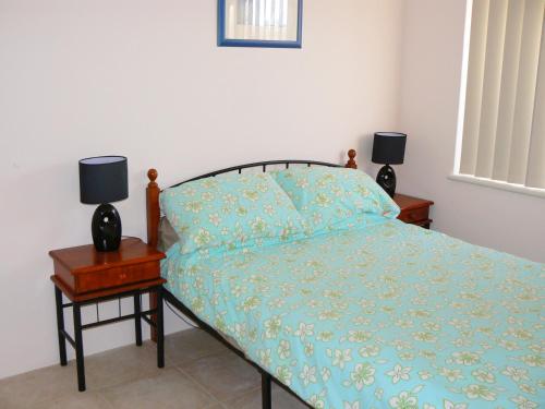 杰拉尔顿Geraldton Luxury Vacation Home with free Streaming的一间卧室配有一张床,床头柜上配有两盏灯