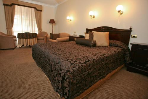 达博澳大利亚遗产汽车酒店的酒店客房带一张大床和一把椅子
