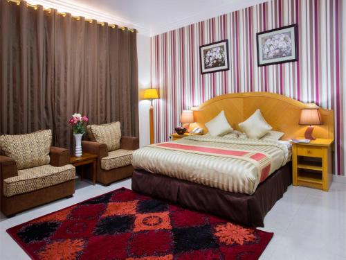 马斯喀特萨费酒店套房的配有一张床和一把椅子的酒店客房