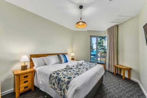 长滩港伯尼海滨港公寓式酒店的一间卧室设有一张大床和一个窗户。
