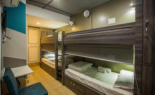 贾姆谢德布尔Pod N Beyond Smart Hotel的配有2张双层床的客房配有书桌和椅子。