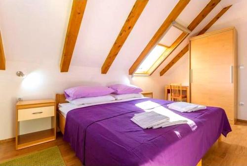 科洛塞普Sandy Beach Apartments的阁楼上一间卧室配有一张紫色床