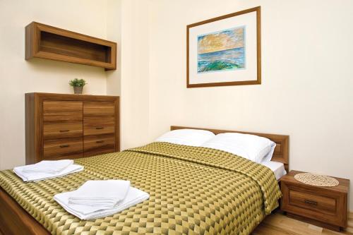 米兹多洛杰Apartament Aquamarina Międzyzdroje的一间卧室配有一张带白色毛巾的床