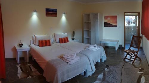 马尔塔赫厄Greenfire Desert Lodge的一间卧室配有两张床和椅子