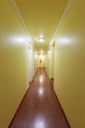 贝洛奥里藏特Hotel Boa Viagem的一条空的走廊,在公寓里,有黄色的墙壁和木地板